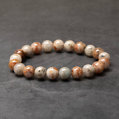Beaded bracelet with brown and white stones on a dark gray background