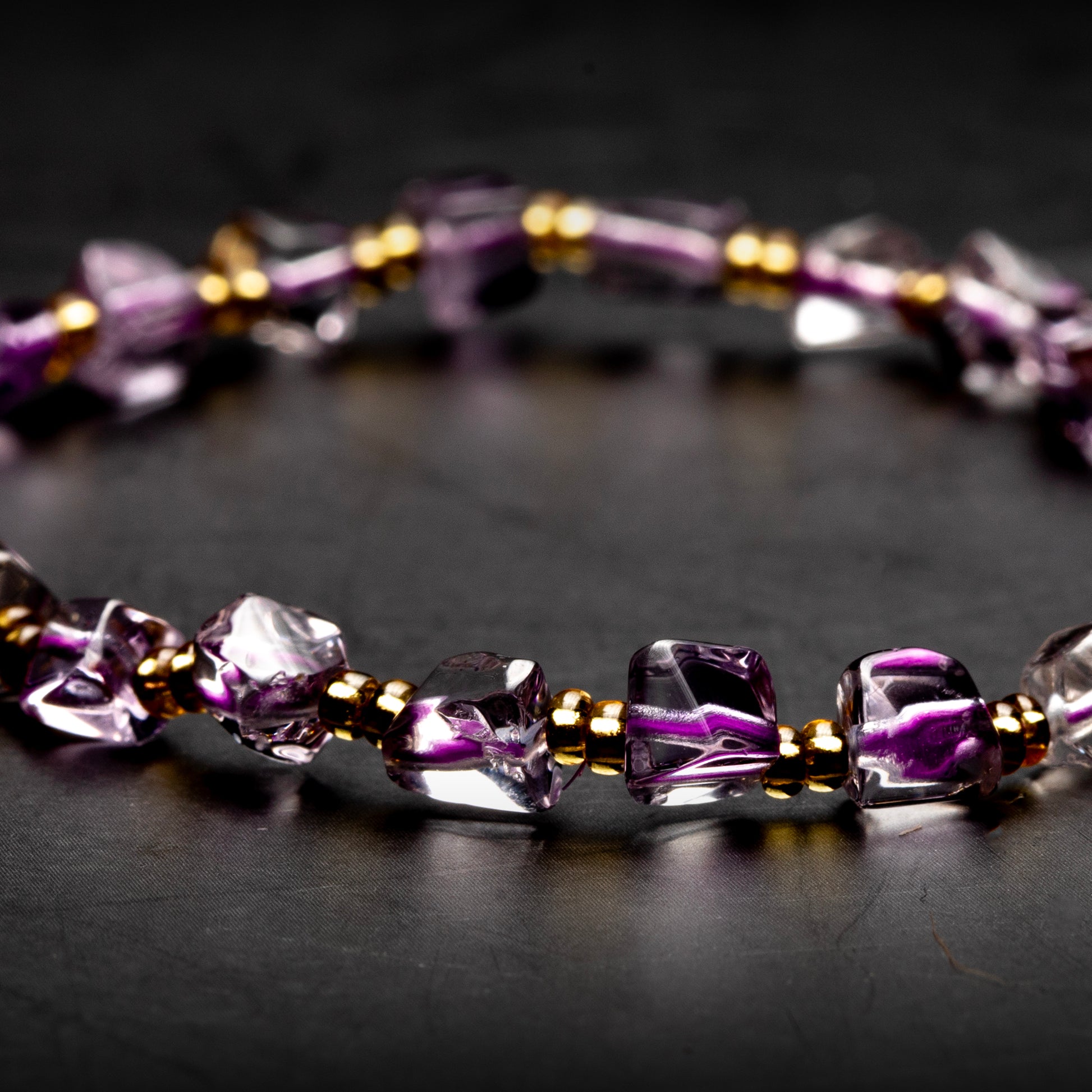 Purple beaded bracelet on a dark surface