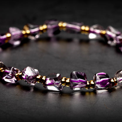 Purple beaded bracelet on a dark surface