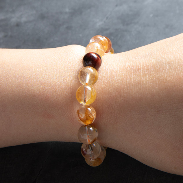 Bracelet with multicolored beads on a wrist against a dark background