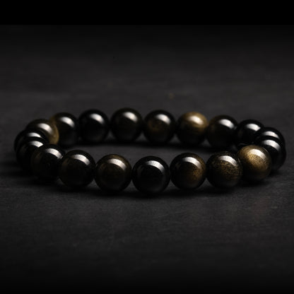 Black and gold beaded obsidian bracelet on a dark background