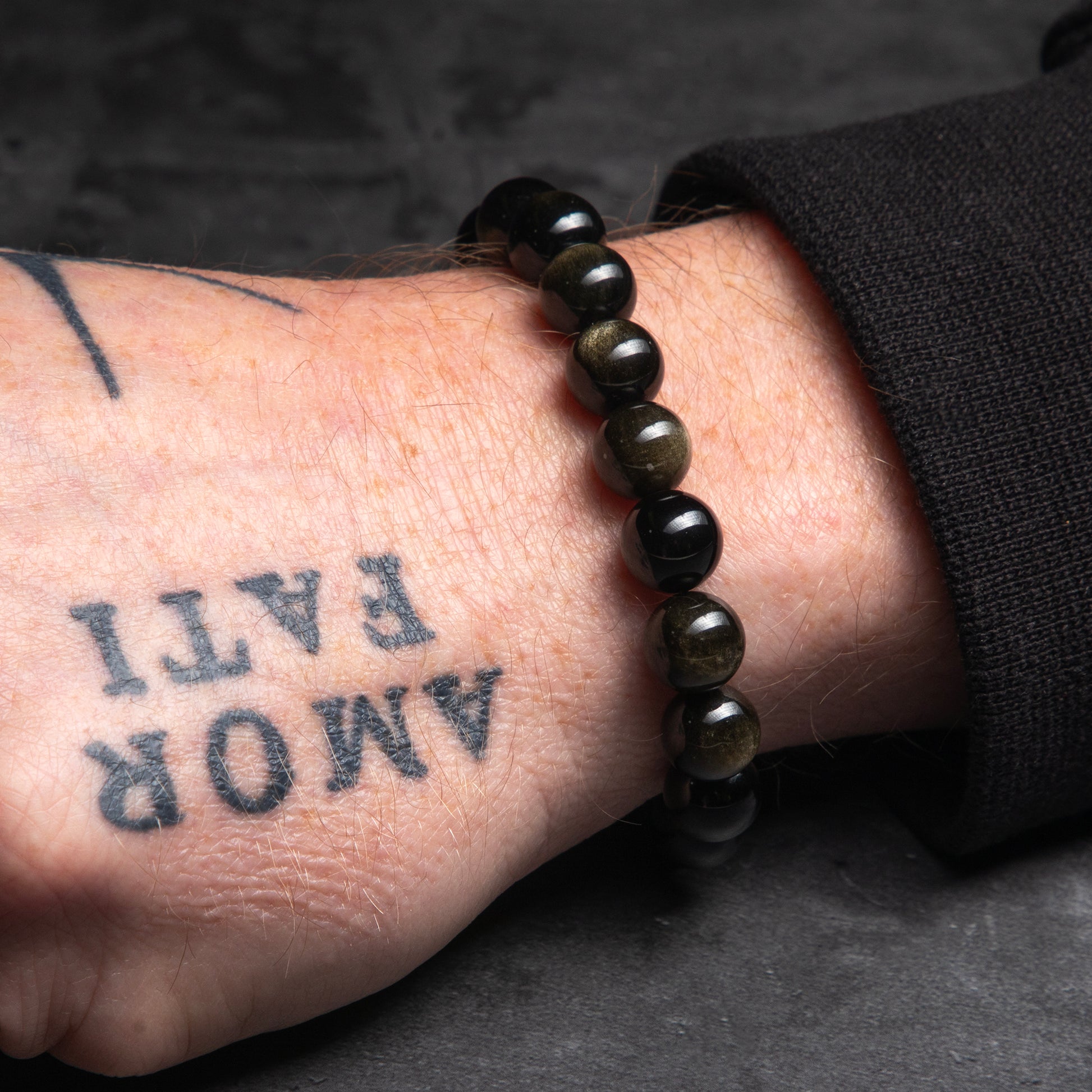 black bracelt on a tattooed hand of a man