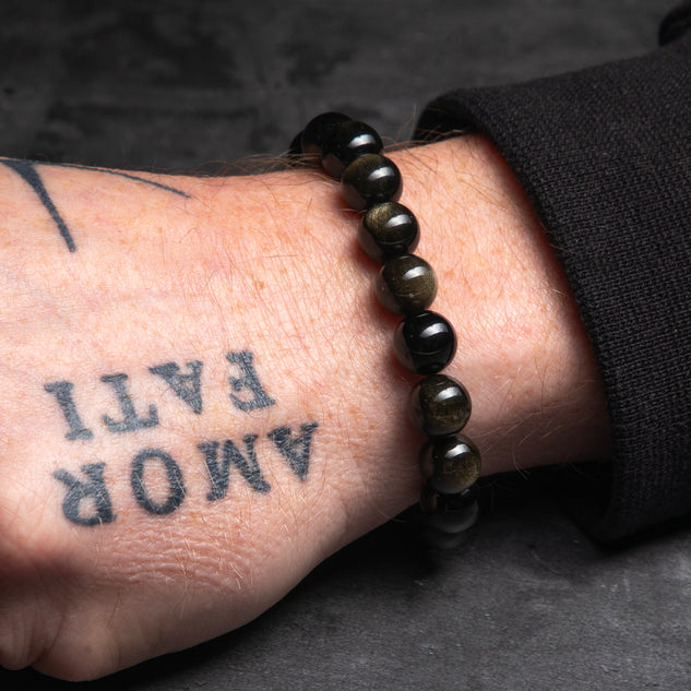 black bracelt on a tattooed hand of a man