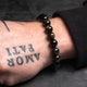 black bracelt on a tattooed hand of a man