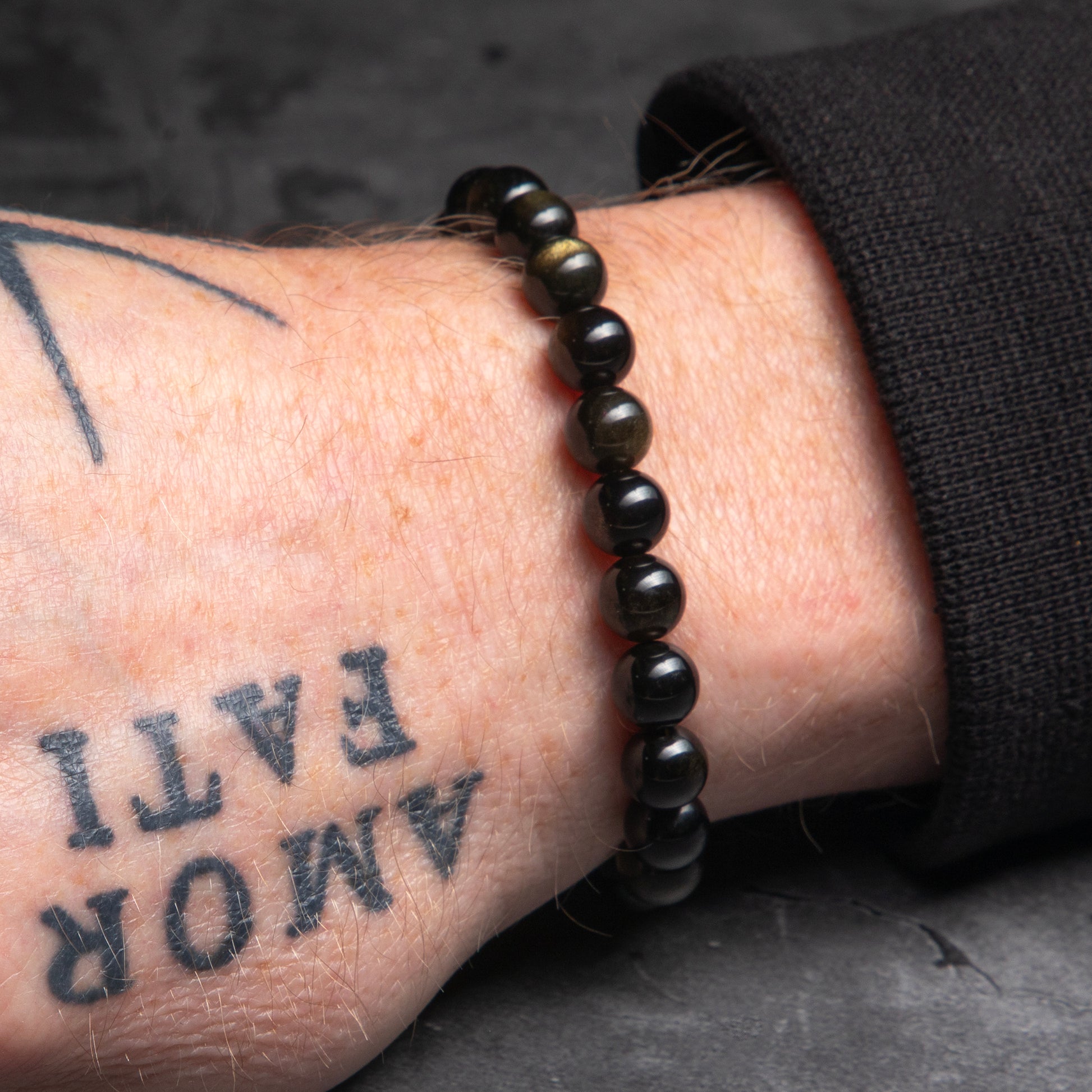 black bracelet worn of the wrist of man