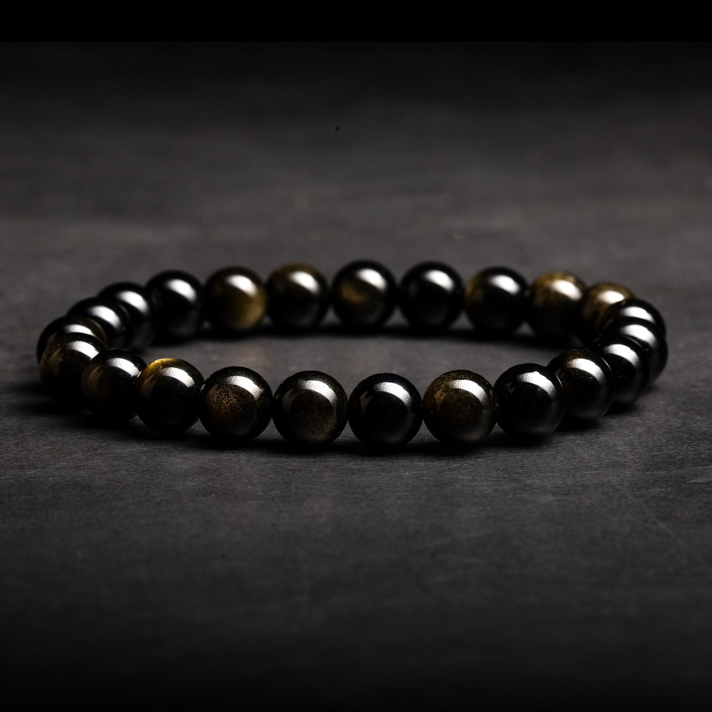 Black beaded bracelet on a dark gray background