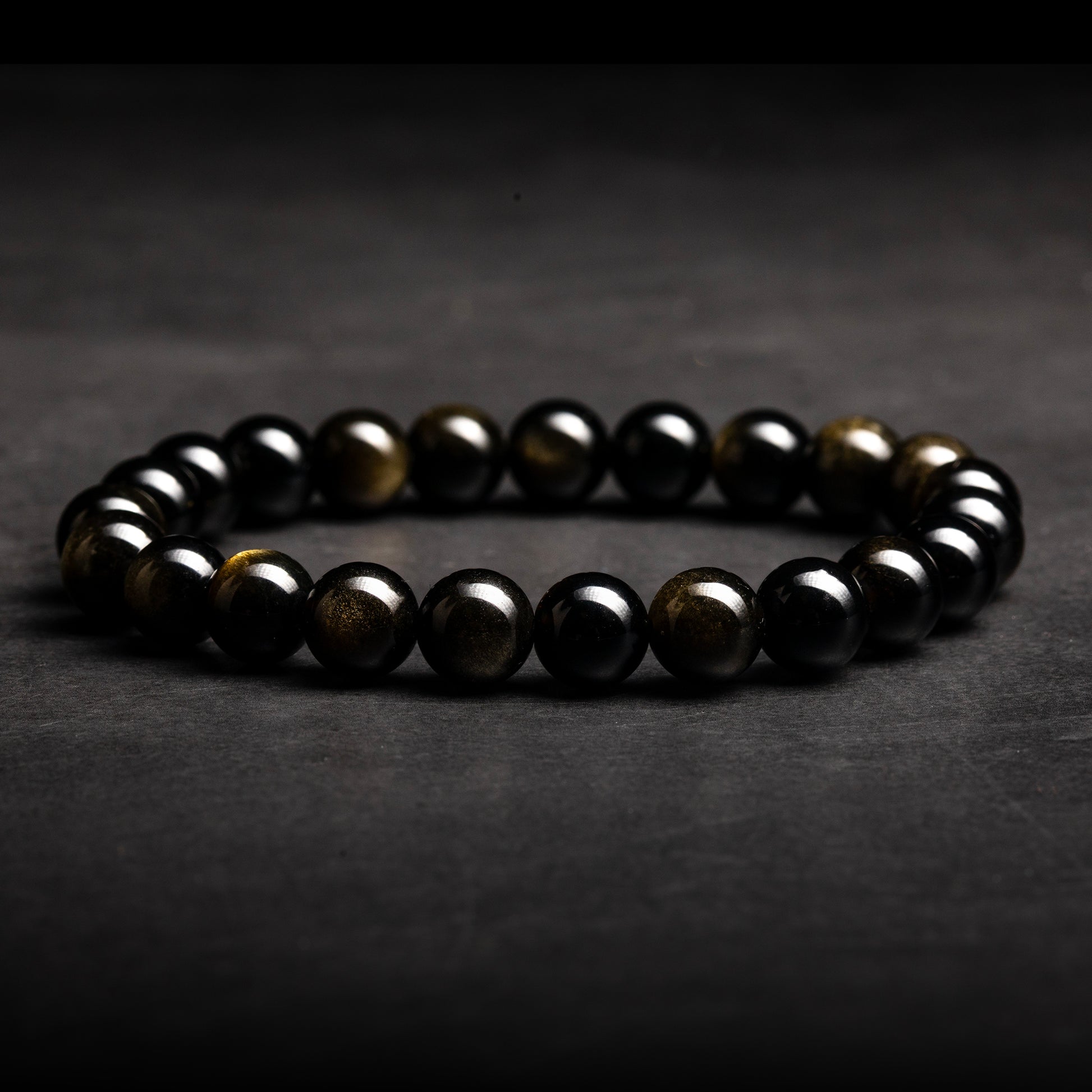 Black beaded bracelet on a dark gray background