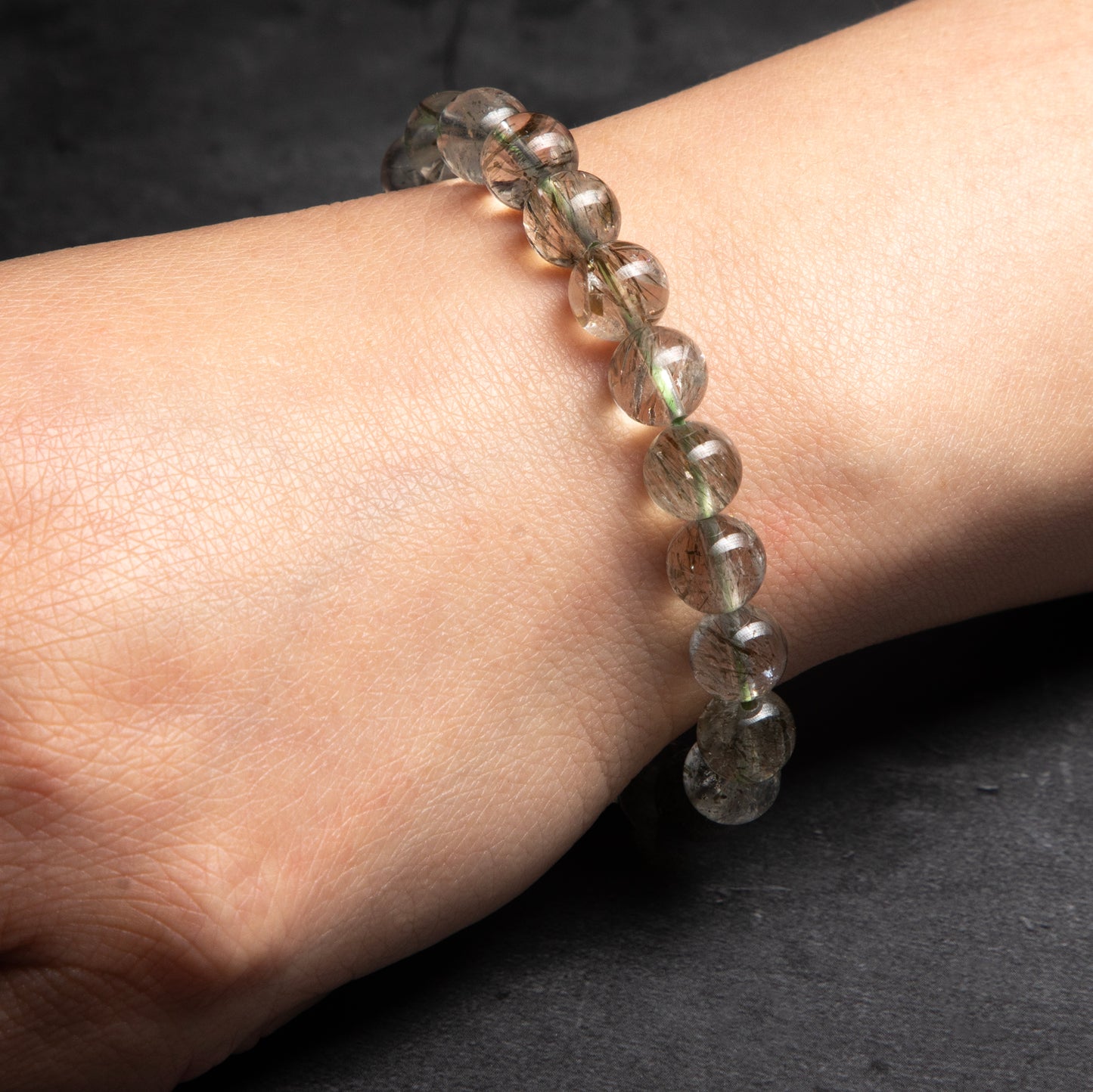 Beaded bracelet on a wrist against a dark background