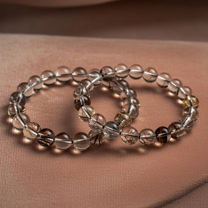 two beaded braclets rest on peach coloured velvet