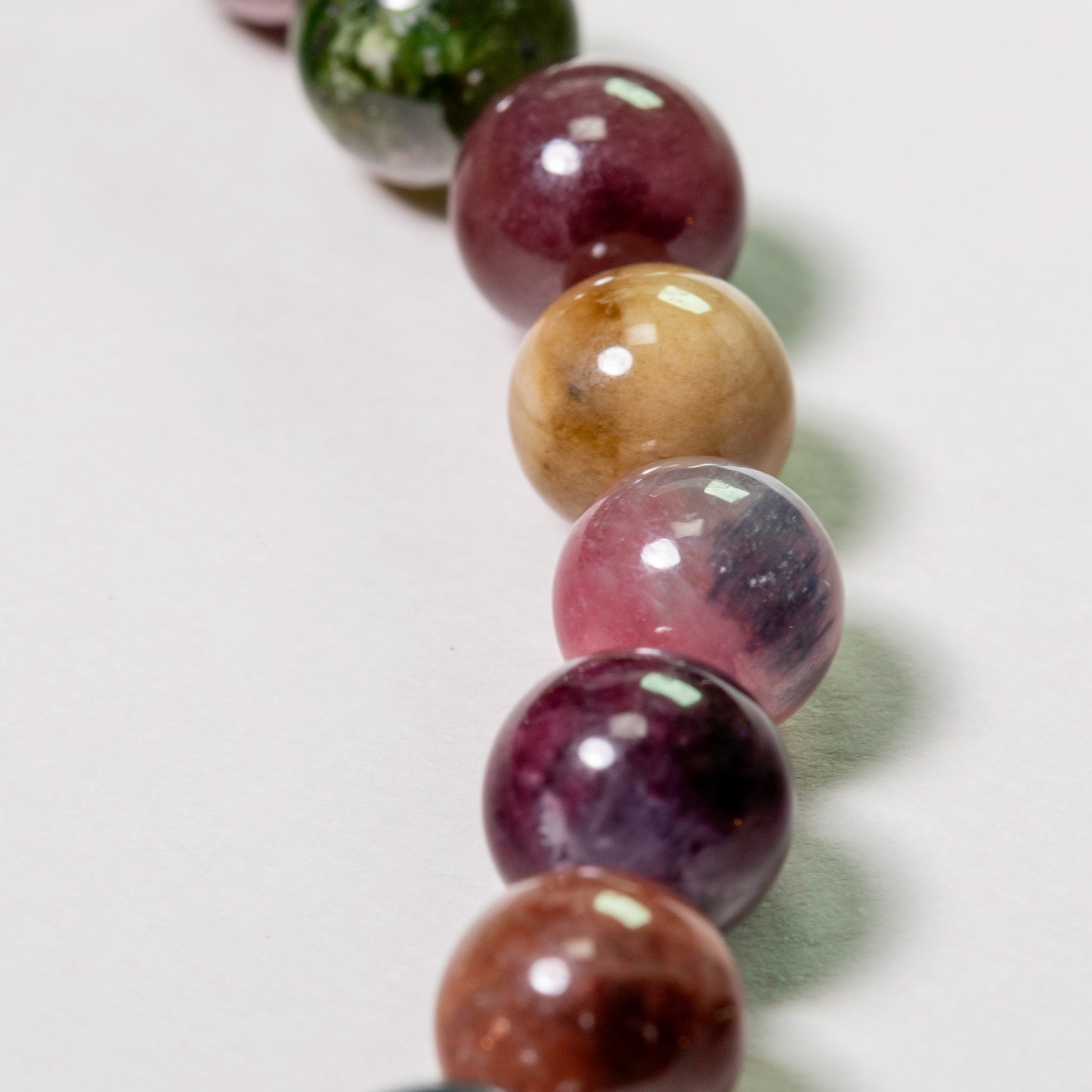 Close-up of a bracelet with multicolored beads on a light background