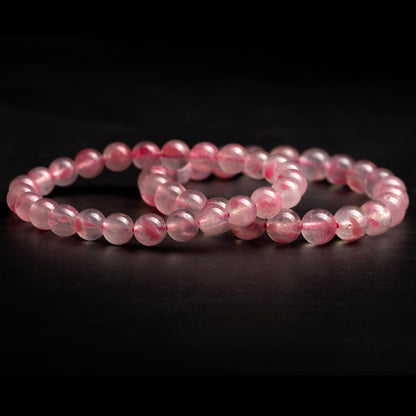 Two pink beaded bracelets on a black background