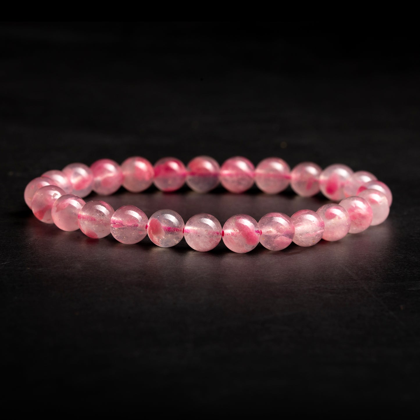 Pink beaded bracelet on a dark background