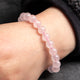 Pink beaded bracelet on a wrist with a blurred background