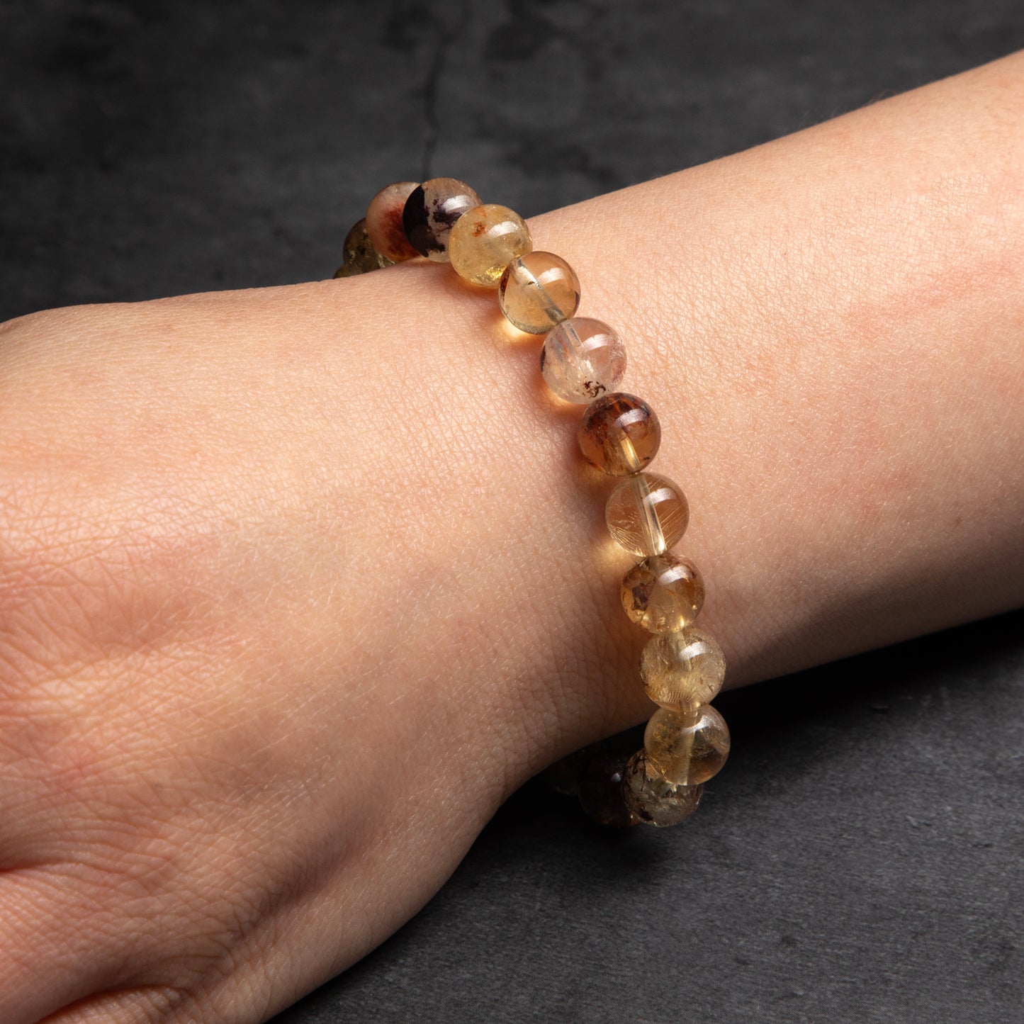 Beaded bracelet on a wrist against a dark background