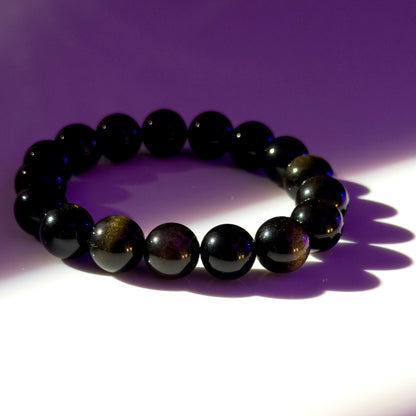 Black beaded bracelet on a purple background