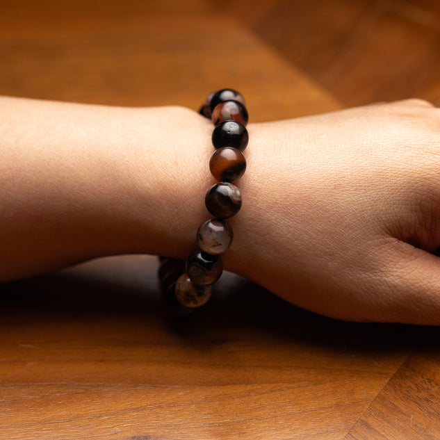 Beaded bracelet on a wrist against a wooden background