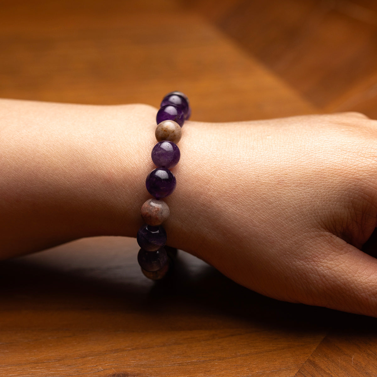 Beaded bracelet on a wrist against a wooden background