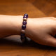 Beaded bracelet on a wrist against a wooden background