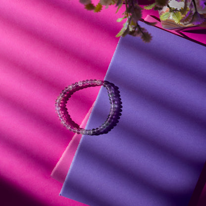 Beaded bracelet on a pink and purple fabric background