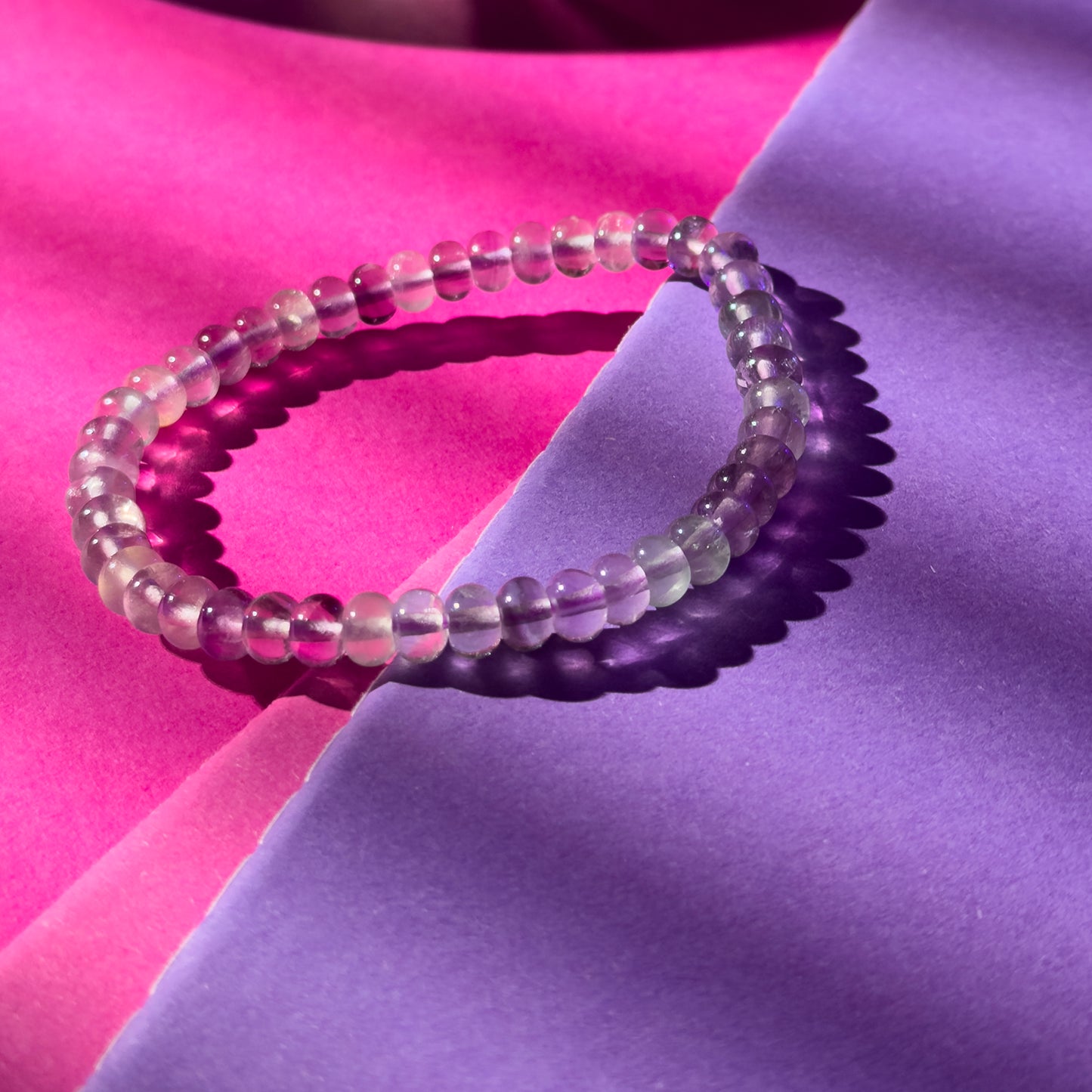 Beaded bracelet on a pink and purple fabric background