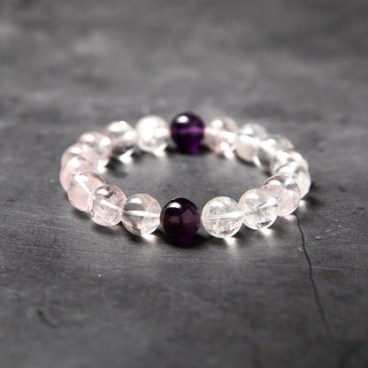 Beaded bracelet with clear and purple beads on a dark surface