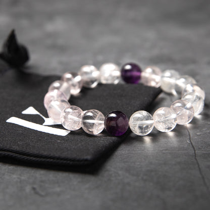 Beaded bracelet with clear and purple beads on a dark surface