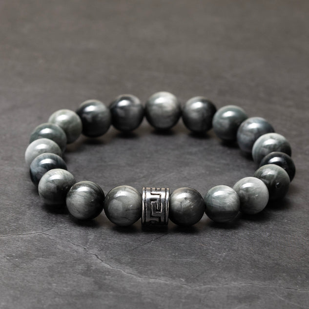 Gray beaded bracelet with a silver clasp on a dark gray background