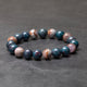 Marbled stone bead bracelet on a dark gray surface