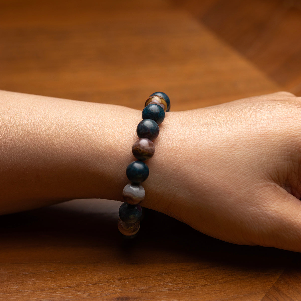 Beaded bracelet on a wrist against a wooden background