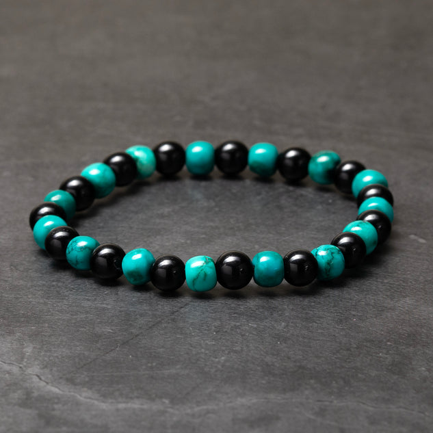 Black and turquoise beaded bracelet on a dark gray background