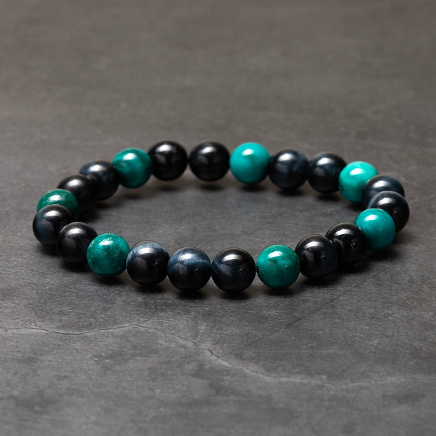 Beaded bracelet with black and turquoise beads on a dark gray background