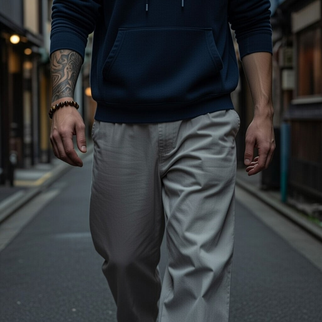 a man wearing a tiger eye bracelet walks down a street
