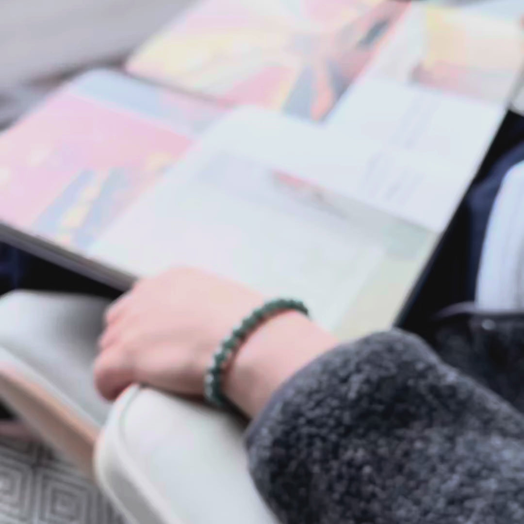video of a green beaded bracelet being worn by a woman