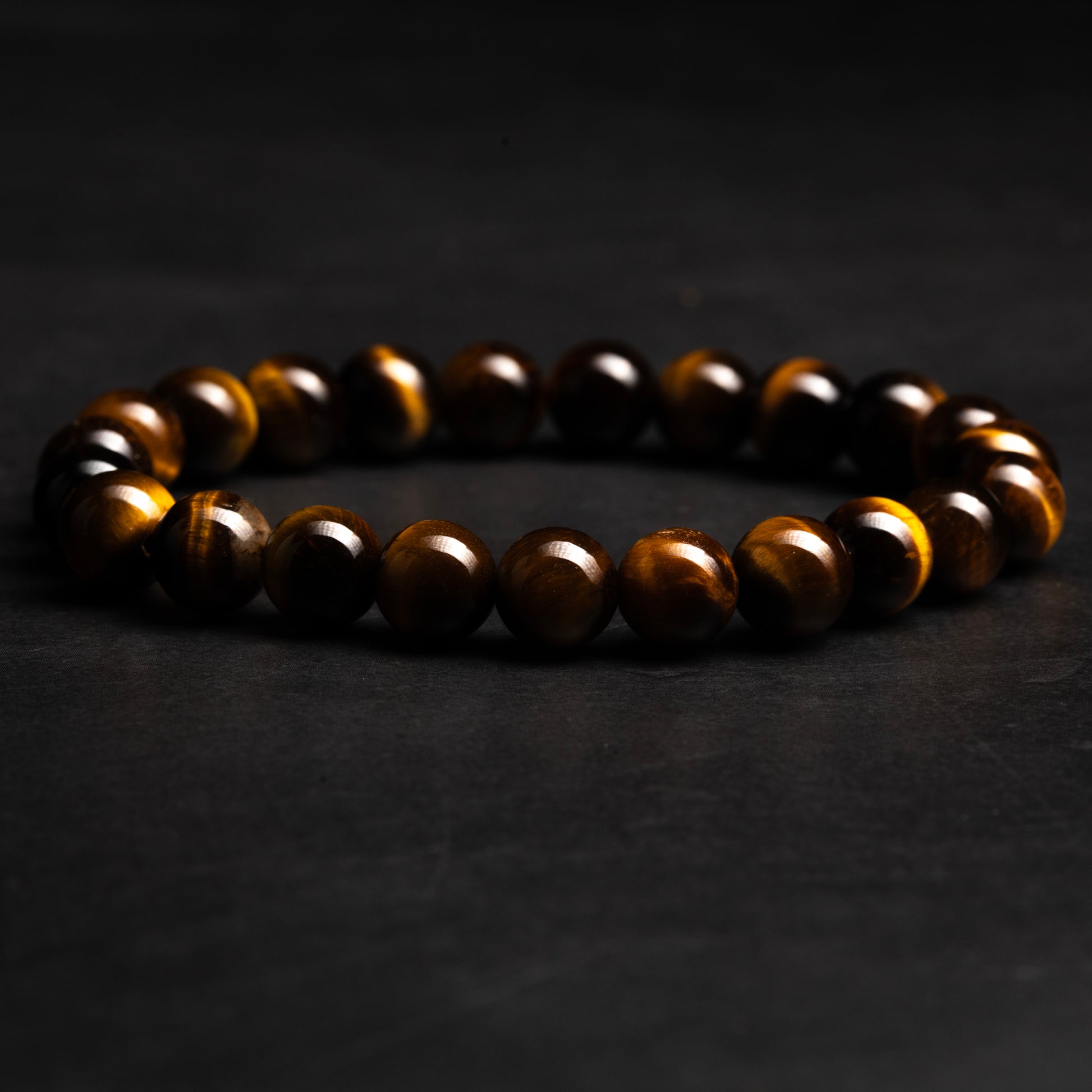 Brown beaded tiger eye bracelet on a dark background